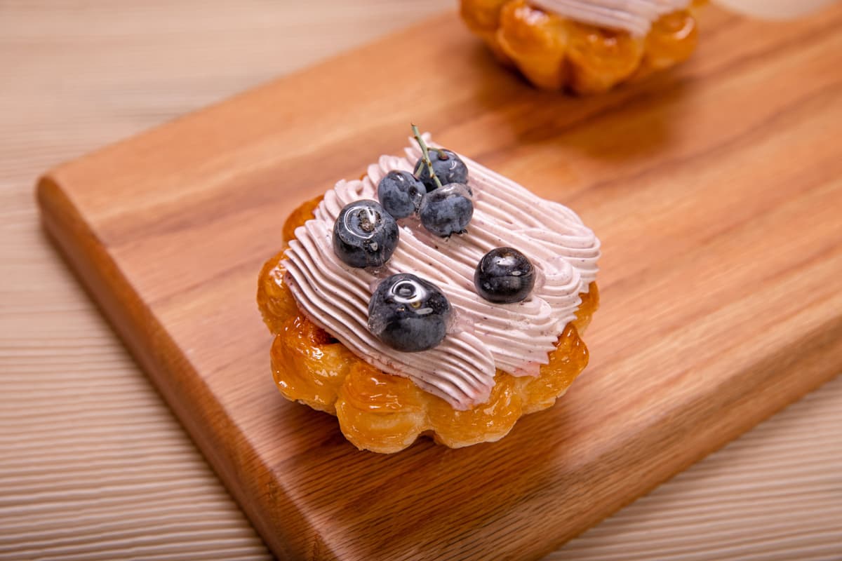 Small fruit tart topped with fresh berries and cream