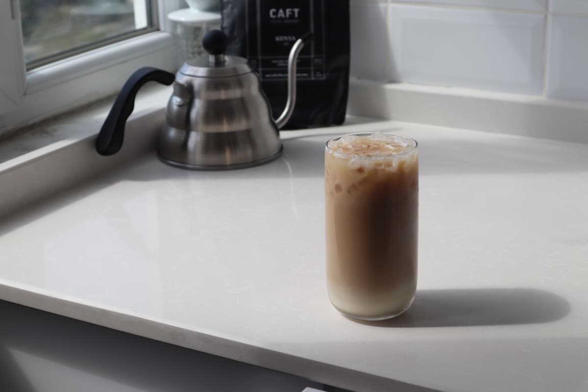Layered iced spanish latte in a tall glass with condensed milk